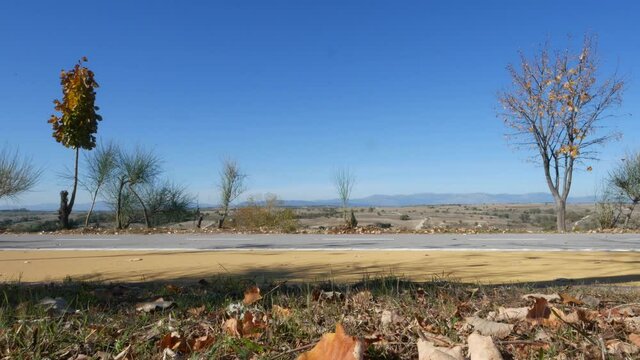 MADRID, SPAIN - Nov 13, 2021: Bike lane with cyclist facing west towards El Pardo mountains. Part of Madrid's Anillo Verde cycle lane network
