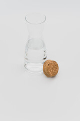 glass carafe with fresh water and cork lid on a white background