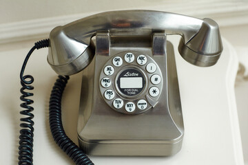 old metal-colored disk phone on a light background