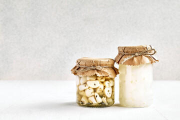 Various canned autumn vegetables in glass jars. Marinated  garlic and  onion on light gray background. Homemade healthy food.