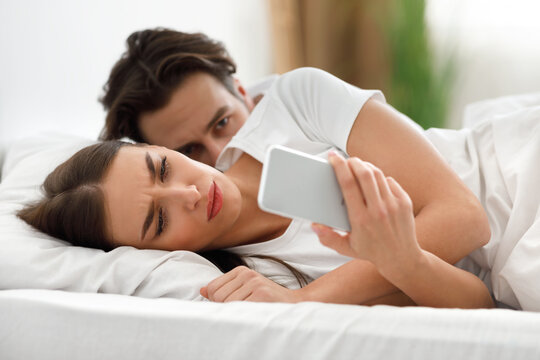 Jealous Husband Reading Unfaithful Wife's Messages While She Texting Indoor