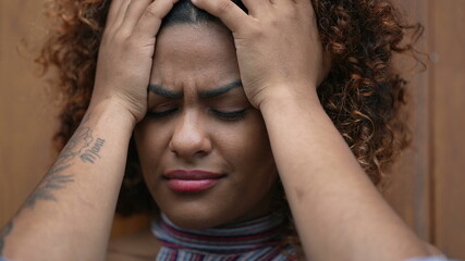 Woman covering face with hand feeling worry and preoccupation