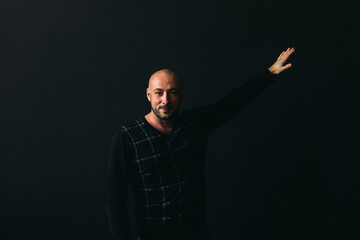 Naklejka premium a young man, businesslike, sociable speaker, says something with gestures. in the studio on a black background.