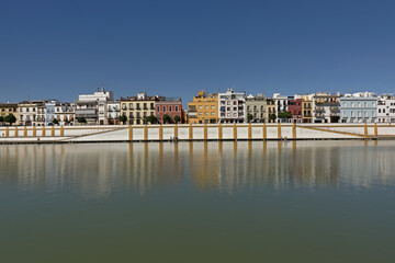 Fototapeta na wymiar Quay of Guadalquivir river with colorful traditional houses of Triana district, Seville, Andalusia, Spain 