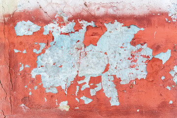 Old weathering cracks with peeling red paint smeared with cleaned wall texture.