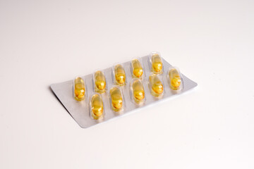 Omega 3 capsules package in blister and separately. Top view fish oil capsules, close-up isolated on white background.
