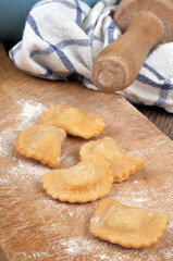 Préparation de raviolis sur une planche à découper  avec un bol de farine et un rouleau à pâtisserie
