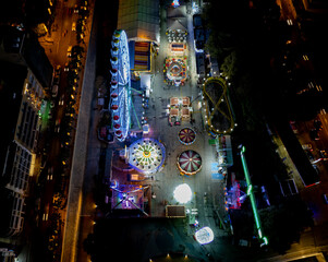 Aerial drone photograph of an amusement park with illuminated games at Christmas season.