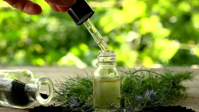Black cumin oil in a bottle. Selective focus.