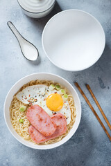 Top view of Hong Kong breakfast or Gong Zai Mein, vertical shot on a light-blue stone background
