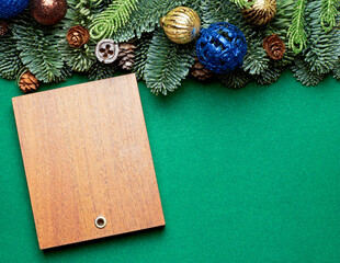 New Year's greeting. wooden background with fir branches, cones and toys.
