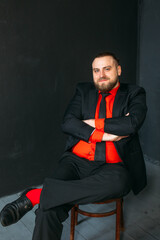 young man, business, sociable speaker, businessman, in a suit with a red shirt, in the studio on a...