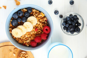 Granola with fruit on a white background. Granola with raspberries, blueberries and banana