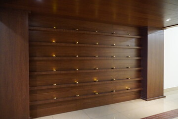 Empty interior background, room with brown wood paneling hardwood wall, many copper lamps in rows. Wooden wall in stylish room Empty office hall with wooden walls and tiled floor. Company grounds.