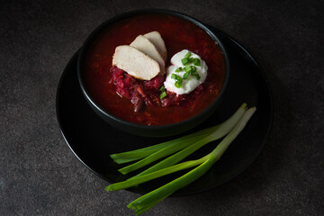 Traditional Ukrainian cuisine - borscht with sour cream and green onions