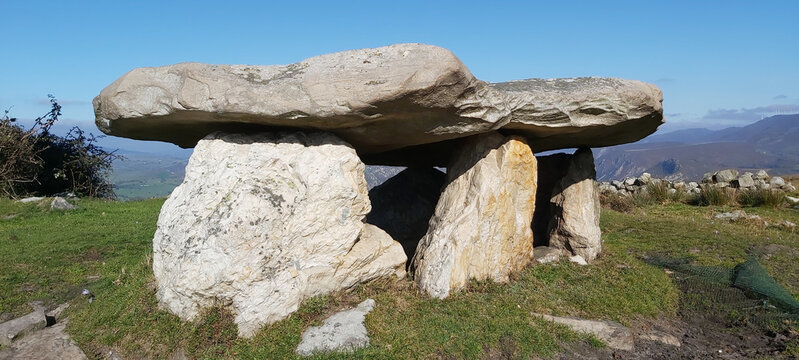 Panorama shot of Dolmens in a field in the daytime.