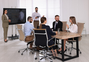 Business training. People in meeting room with interactive board