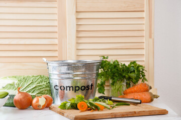 Sorting kitchen waste in compost-bucket on kitchen counter top. Compost-container. Sustainable life style. Vegetable and fruit peels, scraps from food preparation collected in trash-can for recycling