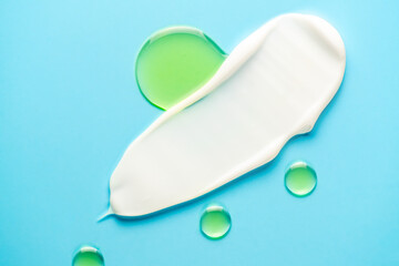 Face care product smears of white creamand beauty oil on blue background. Natural skincare products. Beauty concept for face and body care