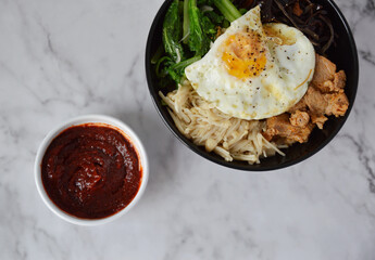 Top view of Korean mixing rice bibimbap with a side of red chili paste