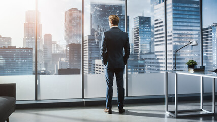 Successful Young Businessman in a Perfect Tailored Suit Standing in His Modern Office Looking out...