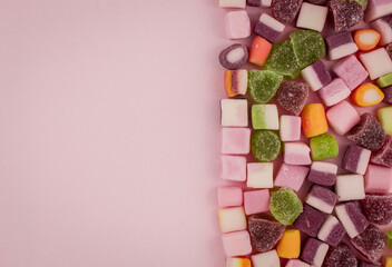 A large pile of mixed sweets on wooden background