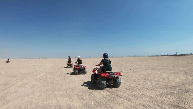 Tourists riding on a quad bikes during safari in the desert near Hurghada, Egypt.