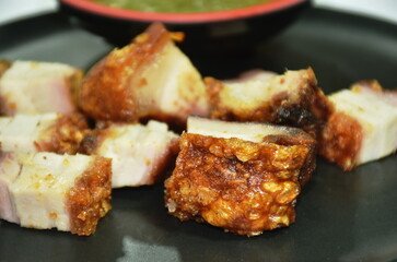 grilled slice crispy pork dipping spicy chili sauce on plate