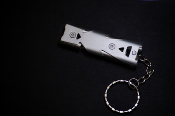 chrome high decibel safety whistle on the black background