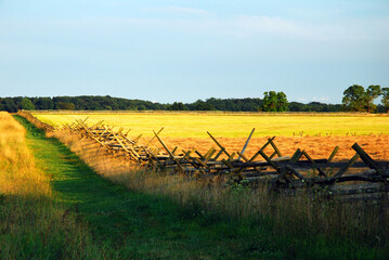 A split rail fence marks a path for hikers to visit the sacred ground of Gettysburg National Battlefield in Pennsylvania.  The site involved one of the bloodiest battles of the American Civil War