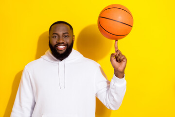 Photo of cool young beard man spin ball wear white sportscloth isolated on yellow color background - obrazy, fototapety, plakaty