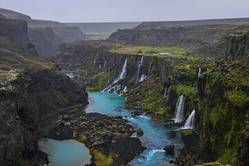 waterfalls at a blue glacial river in the southern highlands of iceland