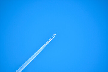 Airplane in the sky with white line as a tail