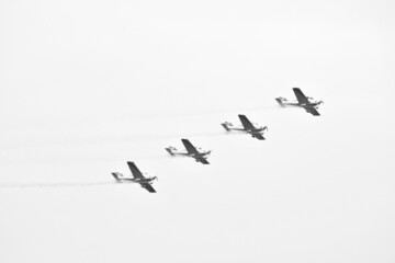 Four antique airplane flying during a grey day