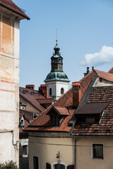 Fototapeta na wymiar Skofja Loka, Slovenia - 04 11 2018: High angle view over rooftops and the church tower of the village