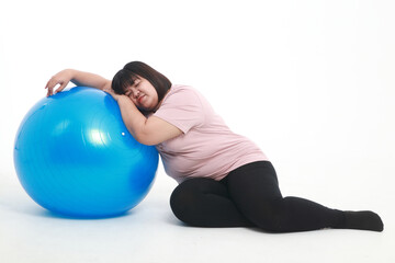 Fat Asian woman tired from exercise Lie on a blue yoga ball on a white background. weight loss exercise concept to have good health