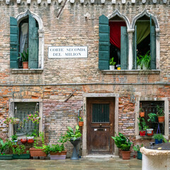 Fototapeta na wymiar Romantic square with flowerpots in backdoor Venice, home of Marco Polo in Corte Milion