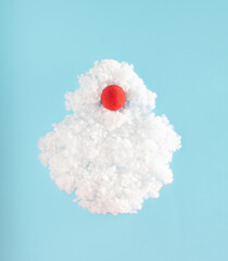 Fluffy wool pile and red ball inside. minimal Santa Claus composition on pastel blue background. Merry Christmas idea.