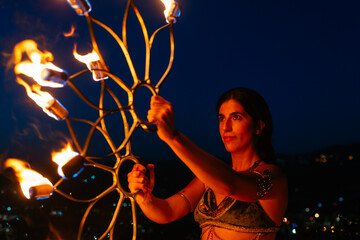 Woman with fire fans at night