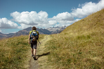traveler walks along a path towards the mountains