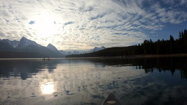 Traveler canoeing into the Spirit Island on Maligne Lake with sunrise on Canadian Rockies at Jasper National Park