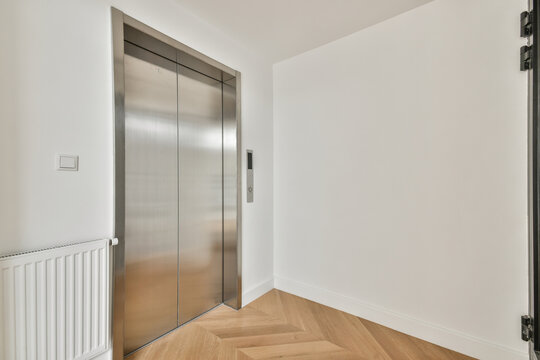 White corridor interior leading to elevator doors
