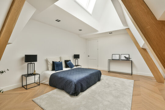 Spacious bedroom interior with bed and slanting walls