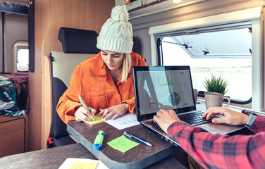 Woman and man telecommuting during a camper van trip