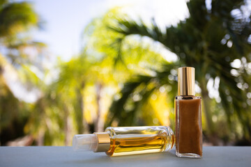 Small bottles of cosmetic liquids on a palm leaves background. Selective focus.