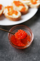 red salmon caviar in a bowl with a spoon on the table close-up dish of red caviar on a festive christmas table