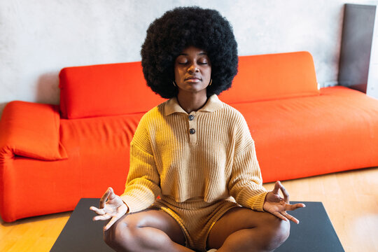 Black woman meditating sitting on table