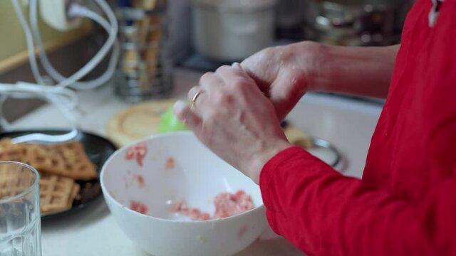 Girl in red longsleeve to cook minced meat cutlets from fresh mea