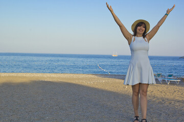 beautiful young woman standing on the beach