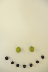 Vertical Photo of a Happy Smile Face Made of Blueberries and Grapes